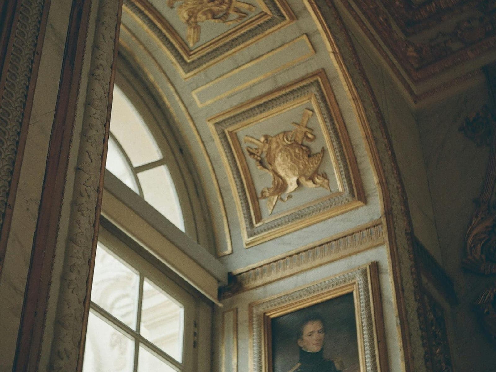 An ornate gilded ceiling and archway inside a grand period interior