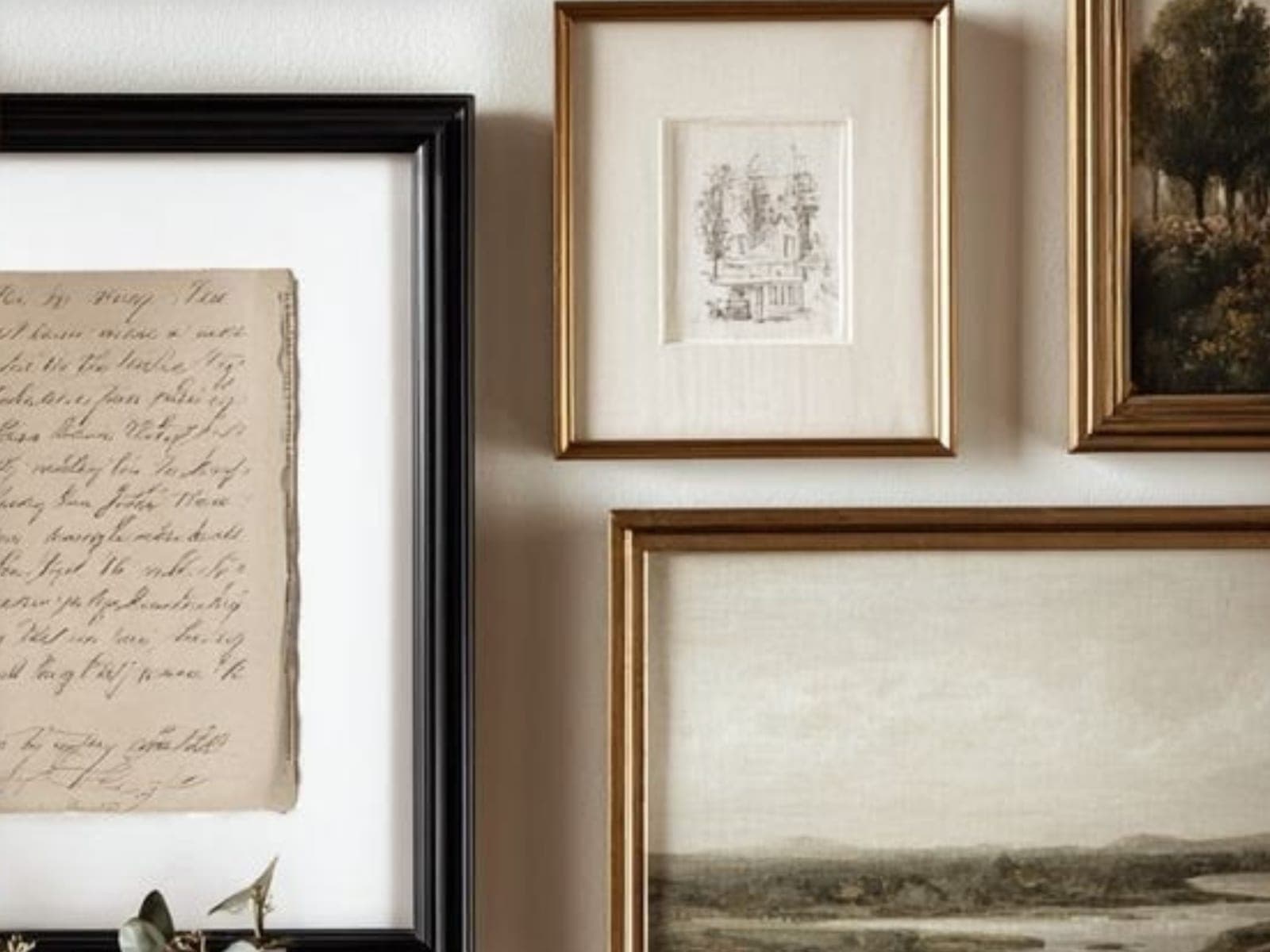 A wall of framed prints and drawings arranged in a considered gallery hang